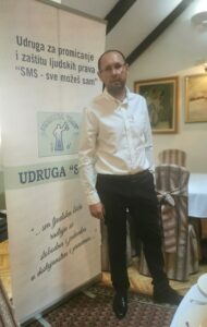 Govornik uz promotivni pano Udruge „SMS“